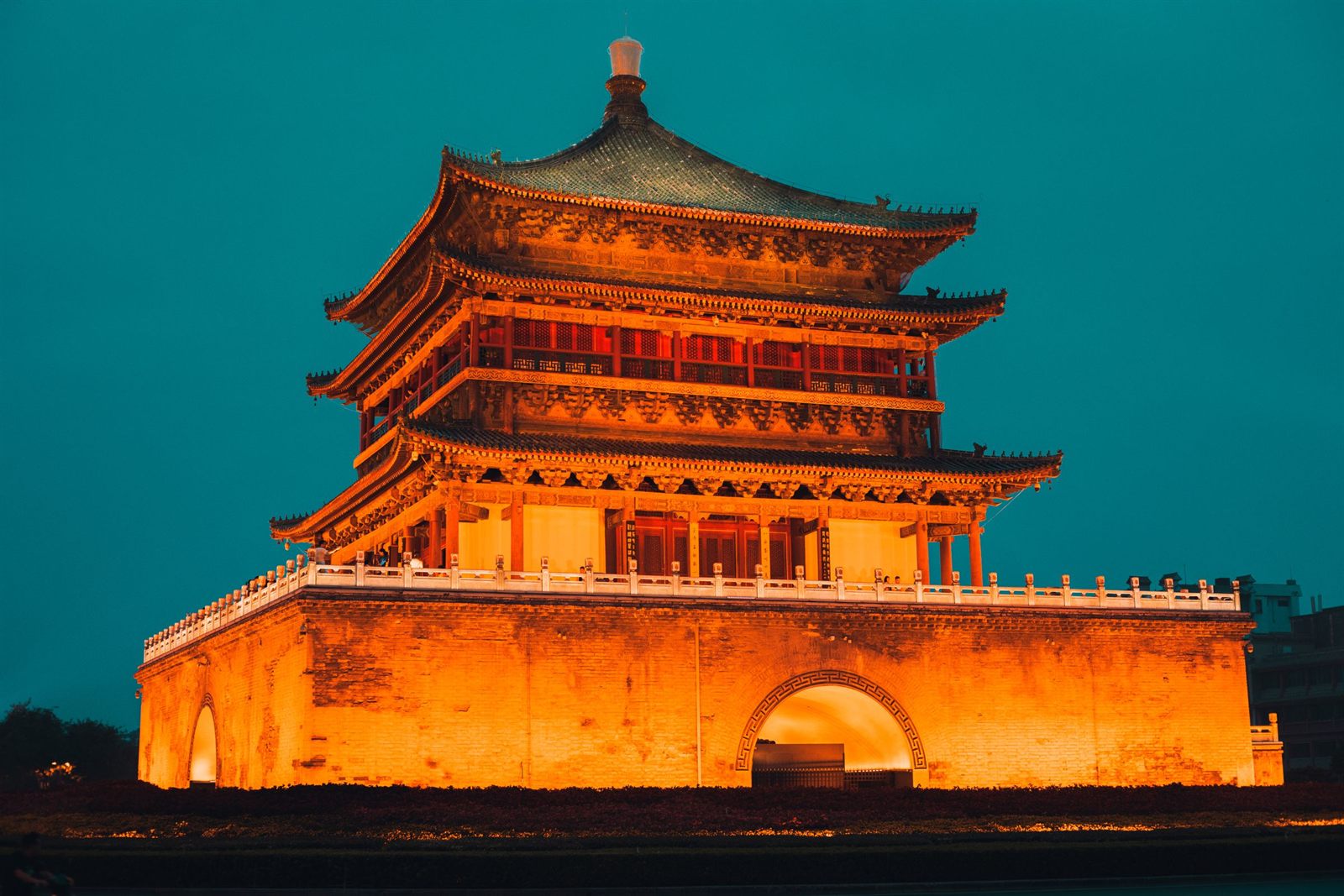 Illuminated Bell Tower of Xi’an glowing orange against a teal evening sky
